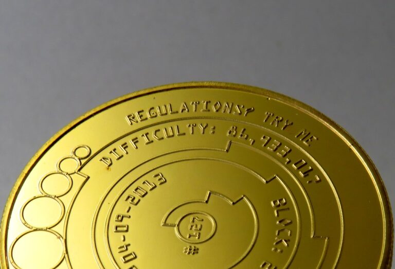 Pieces physiques representant le bitcoin posees sur une surface sombre