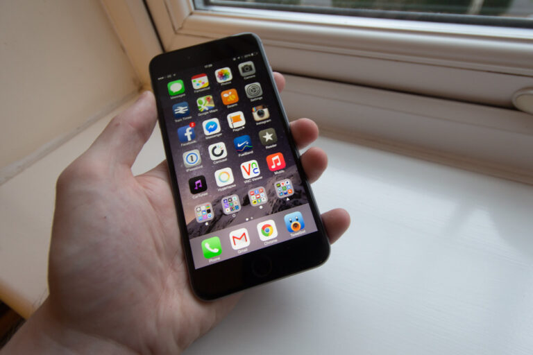 Personne tenant un iPhone dans sa main dans la rue