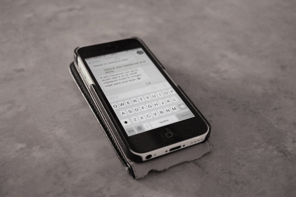 Personne utilisant une application de messagerie sur un smartphone