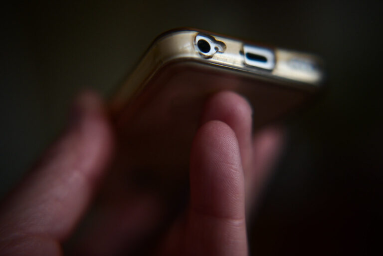 Un smartphone tenu dans une main, illustrant le partage de fichiers entre Android et iPhone