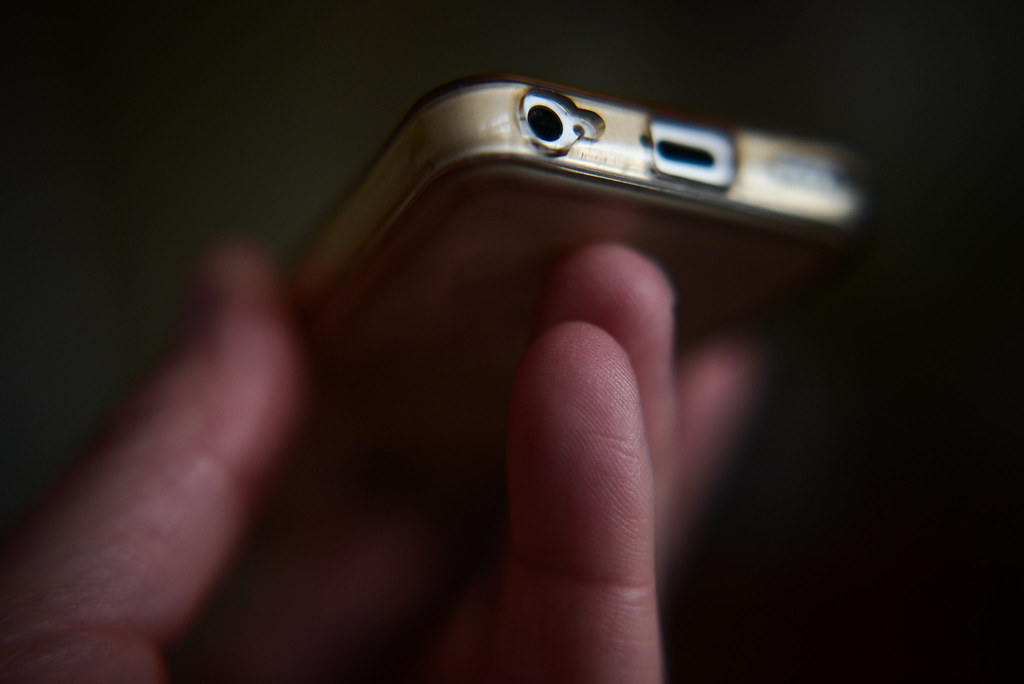 Un smartphone tenu dans une main, illustrant le partage de fichiers entre Android et iPhone