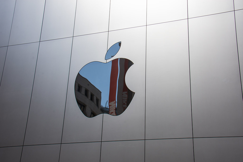 Logo Apple Store se reflétant sur la vitrine d'une boutique