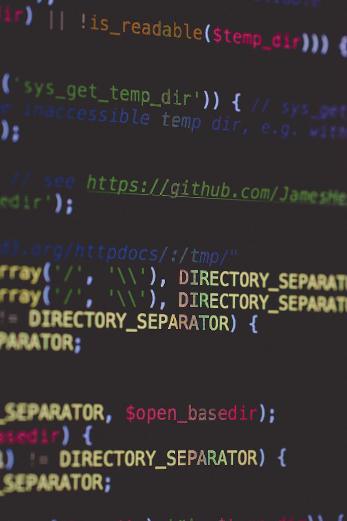 Ecran d'ordinateur affichant du code source HTML, PHP et JavaScript colore
