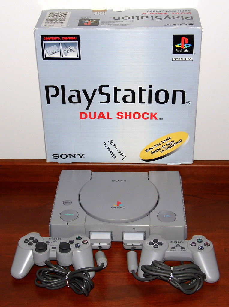Console de jeu PlayStation avec sa manette posee sur une surface