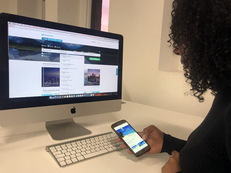 Une vacancière consulte le site d'une agence de voyages sur son smartphone à la recherche d'une offre