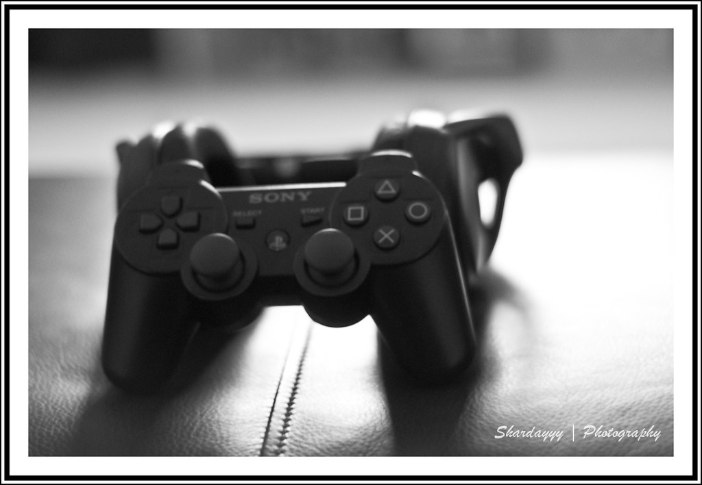 Manette de console posée devant un écran de jeu vidéo