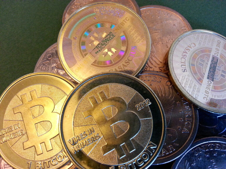 Pièces de bitcoin métalliques posées sur une surface sombre