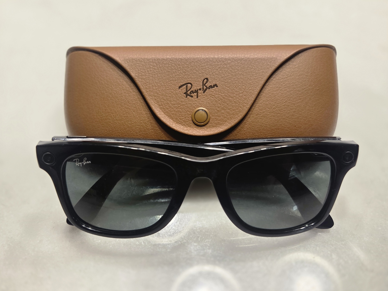 Lunettes connectées Ray-Ban Meta posées à côté de leur étui de recharge