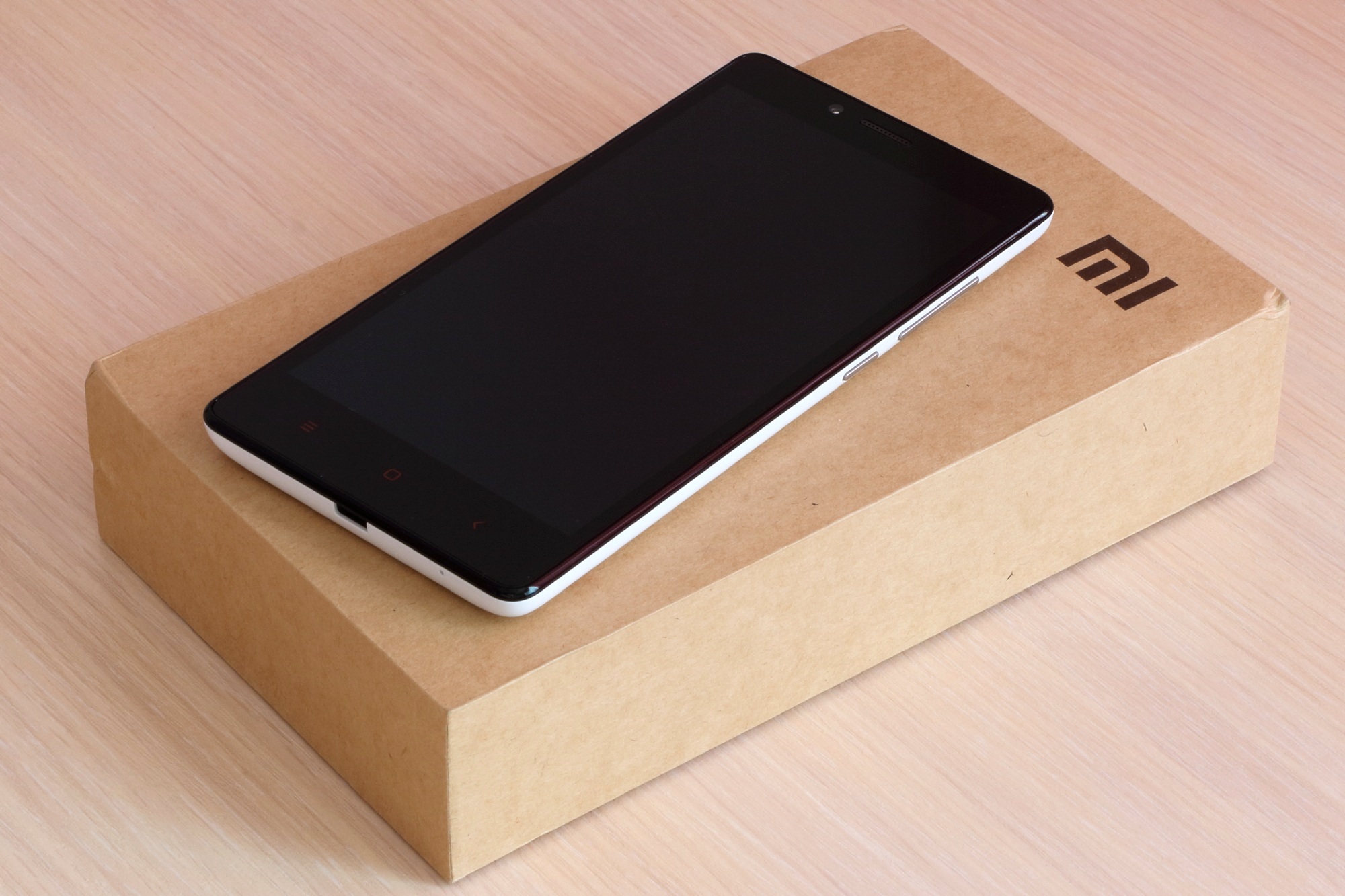 Smartphone Xiaomi Redmi Note posé sur une surface claire