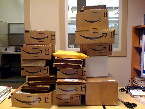 Cartons de livraison Amazon empiles, illustration du changement de facturation Amazon Ads