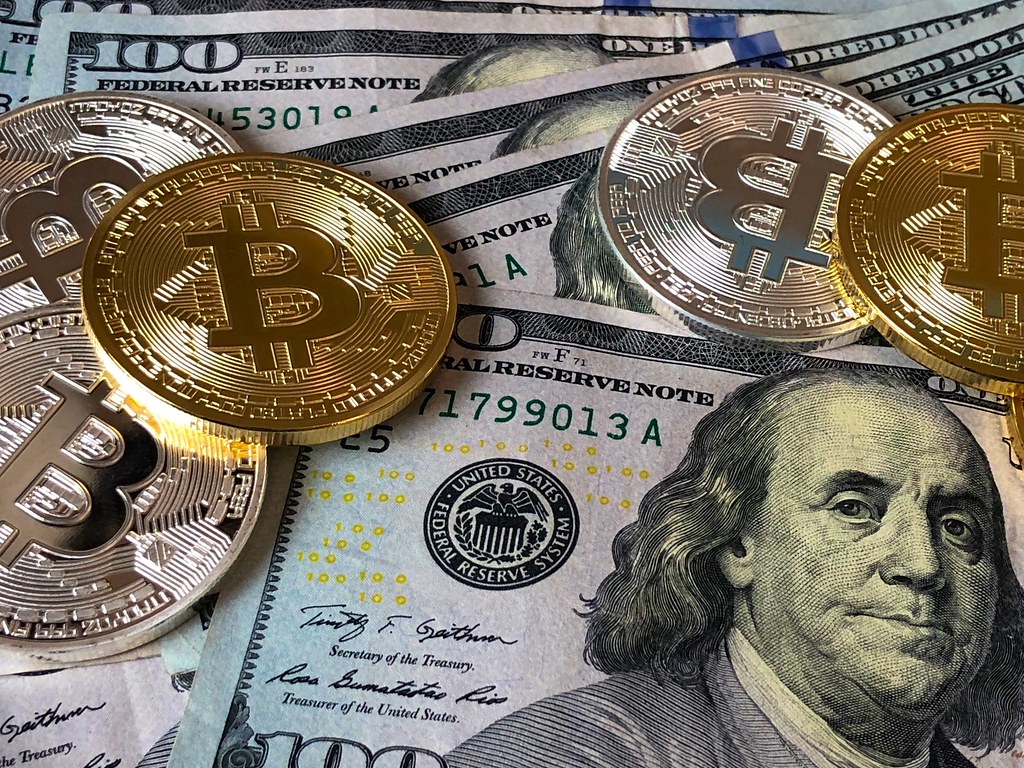 Pièces de cryptomonnaie posées sur des billets en dollars américains