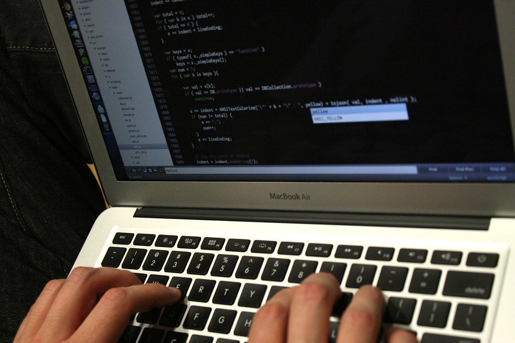 Developpeurs travaillant sur du code informatique devant des ecrans lors d'un hackathon